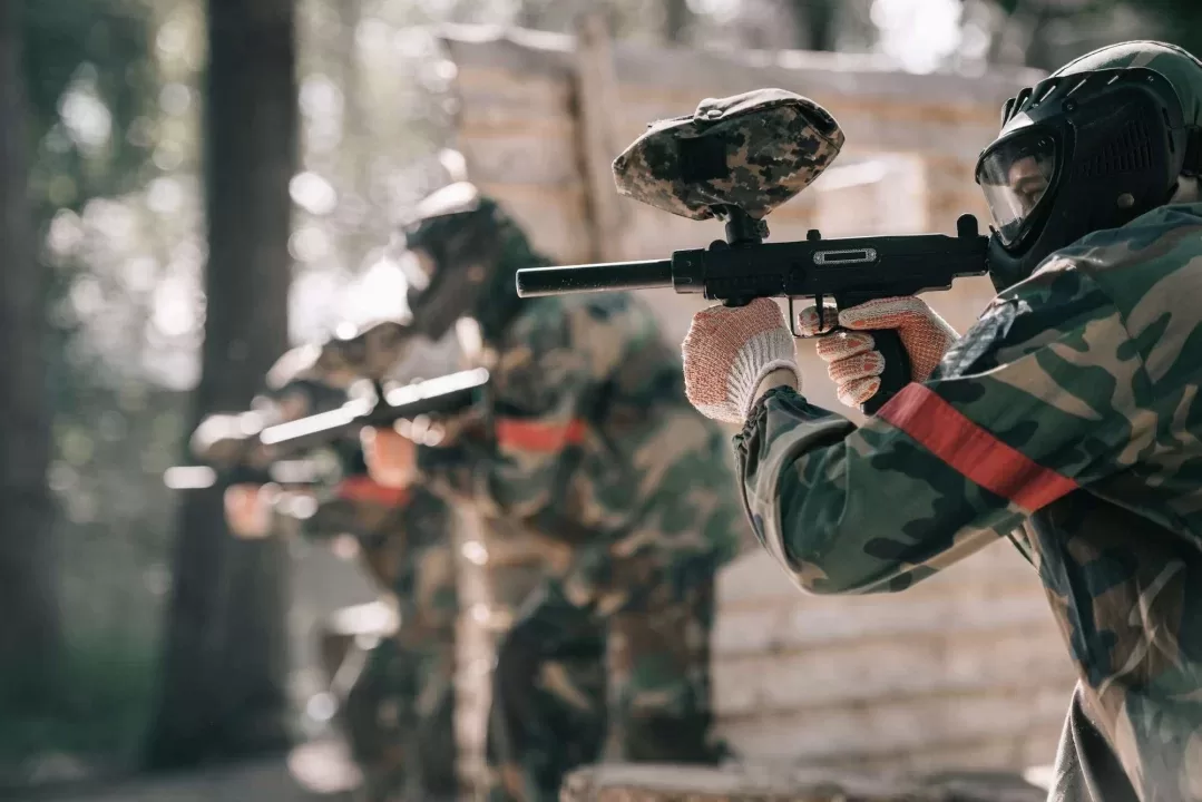 Peserta paintball membidik marker di antara pohon hutan pinus Puncak Bogor
